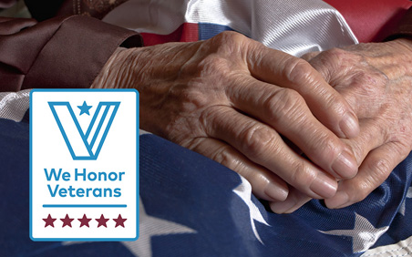 Hands of veteran on top of flag