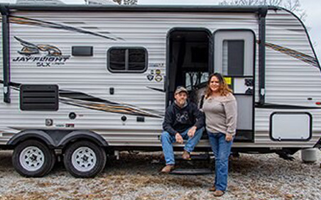 Don and Tania Budd of Shorewood in front of camper