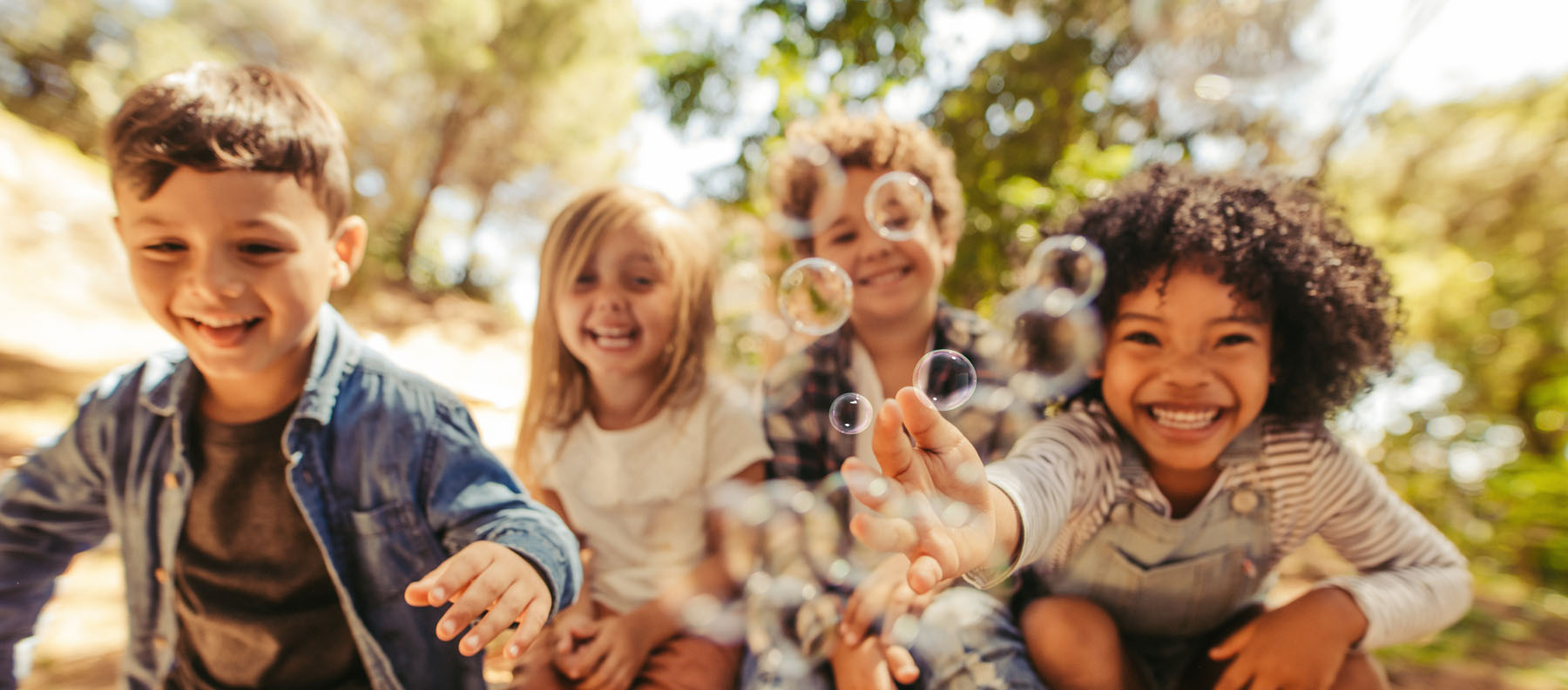 Diverse group of kids playing with bubbles