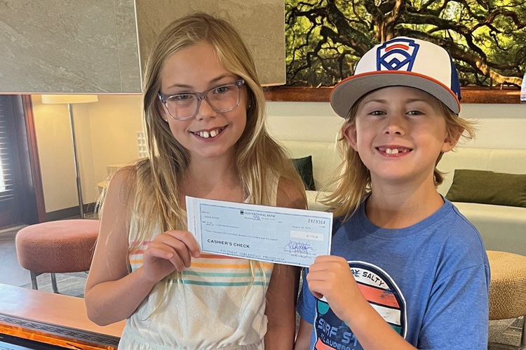 Two kids holding check to Lightways from lemonade stand