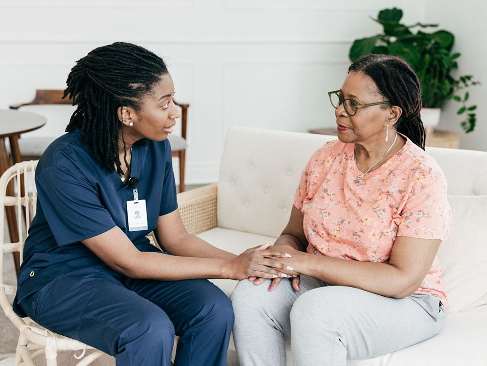 Black nurse comforting black female