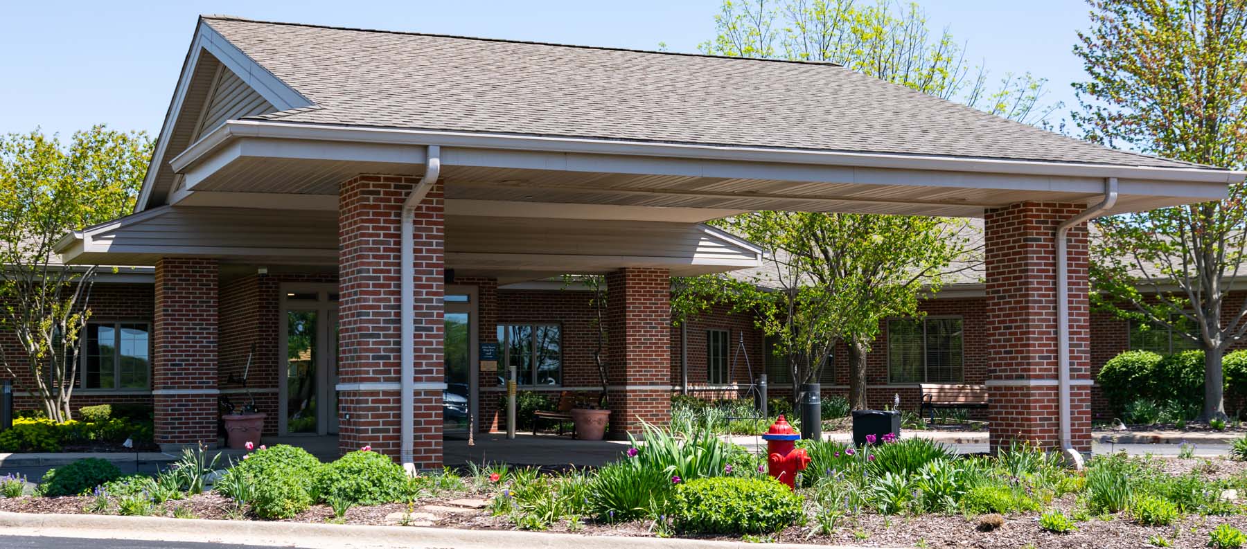 Lightways administrator sitting on blue couch with elderly male reviewing hospice patient care at Lighways Hospice Joliet.